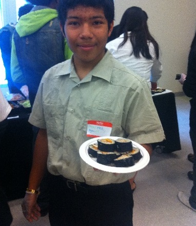 Sophomore Marcel holds up his handmade sushi role at Tuesday's Youth Summit