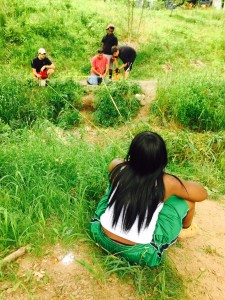 Students from summer site crew measure out for a new footbridge in the wetland.