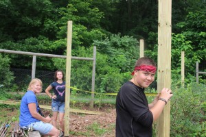 Melissa Spear instructs summer site crew as they measure for the blueberry enclosure.