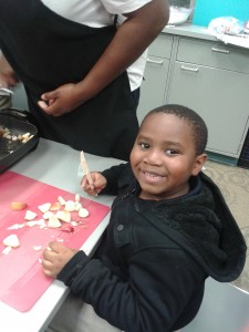 A young boy prepares ingredients fin the Kidz Kook cooking class.