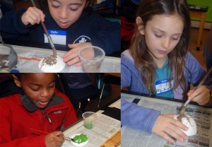 Three young students participate in Common Ground's February vacation programs by painting plaster casts of animal tracks.