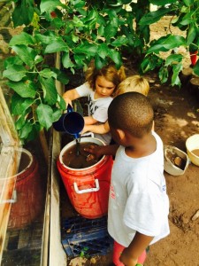 Three boys play and discover in the mud kitchen.