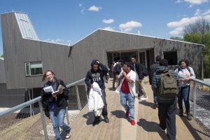 Common Ground High School students walk along the bridge by the new building.