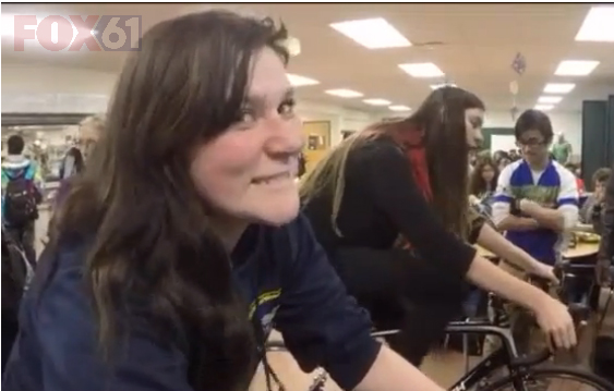 A Common Ground High School student rides a training bike in the cafeteria during lunch.