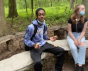 CG juniors around campfire in woods talk about college essays