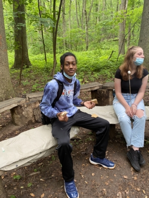 CG juniors around campfire in woods talk about college essays